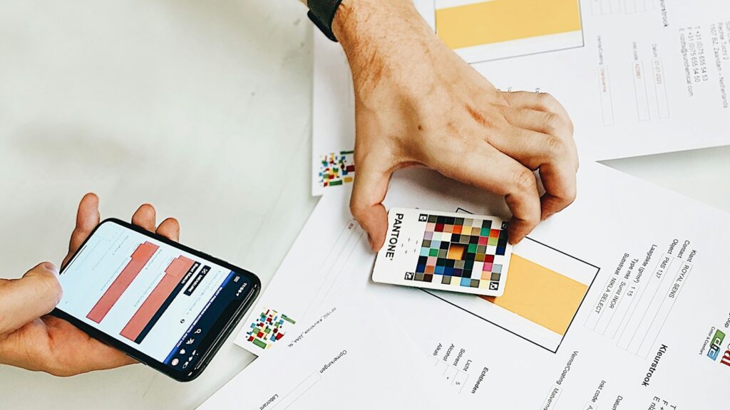 Person holding iphone on white printer paper
