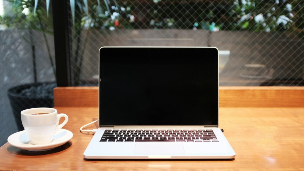 Laptop computer beside coffee mug