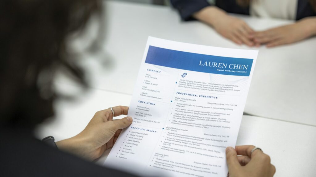 A woman is reading a resume at a table