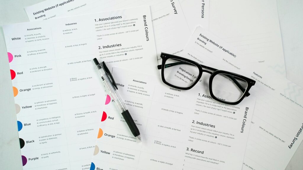 A pair of glasses sitting on top of a pile of paper