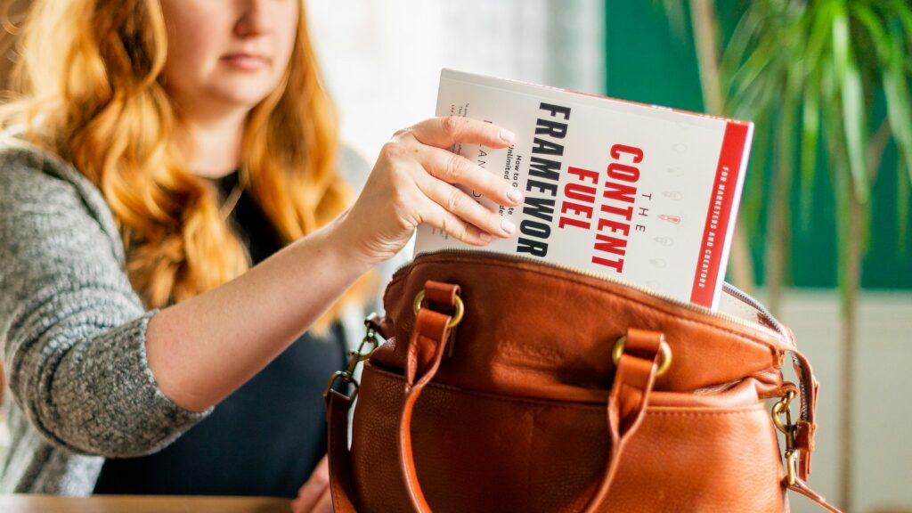 Woman holding brown leather handbag