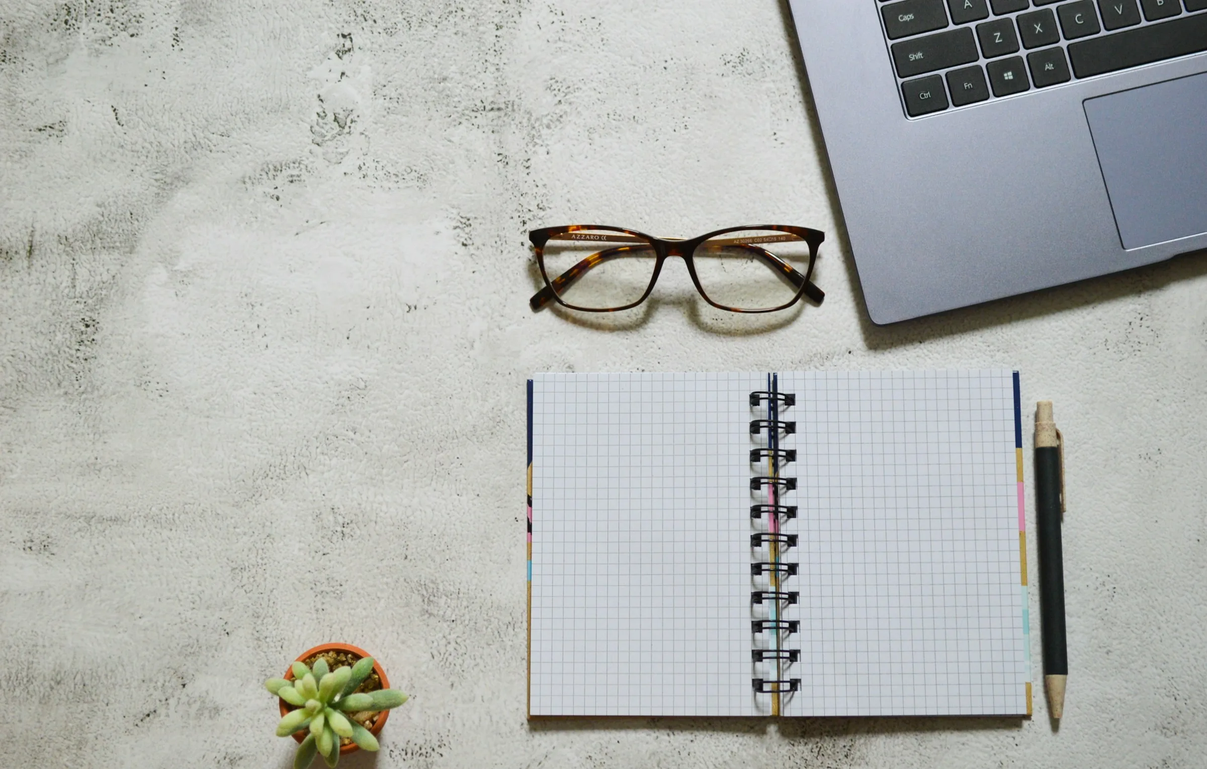 Notebook, pen and glasses on a desk