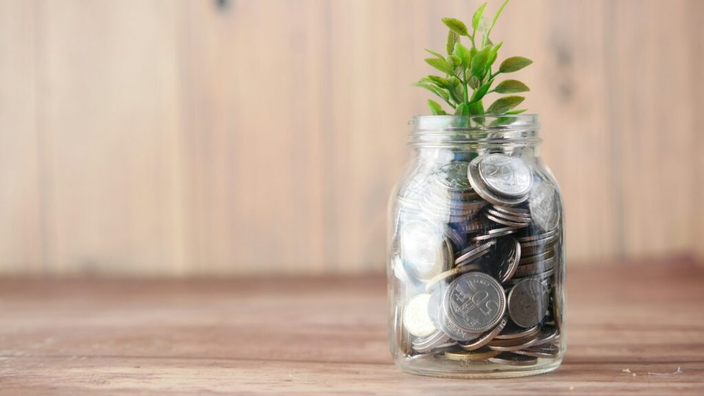 A glass jar filled with coins and a plant