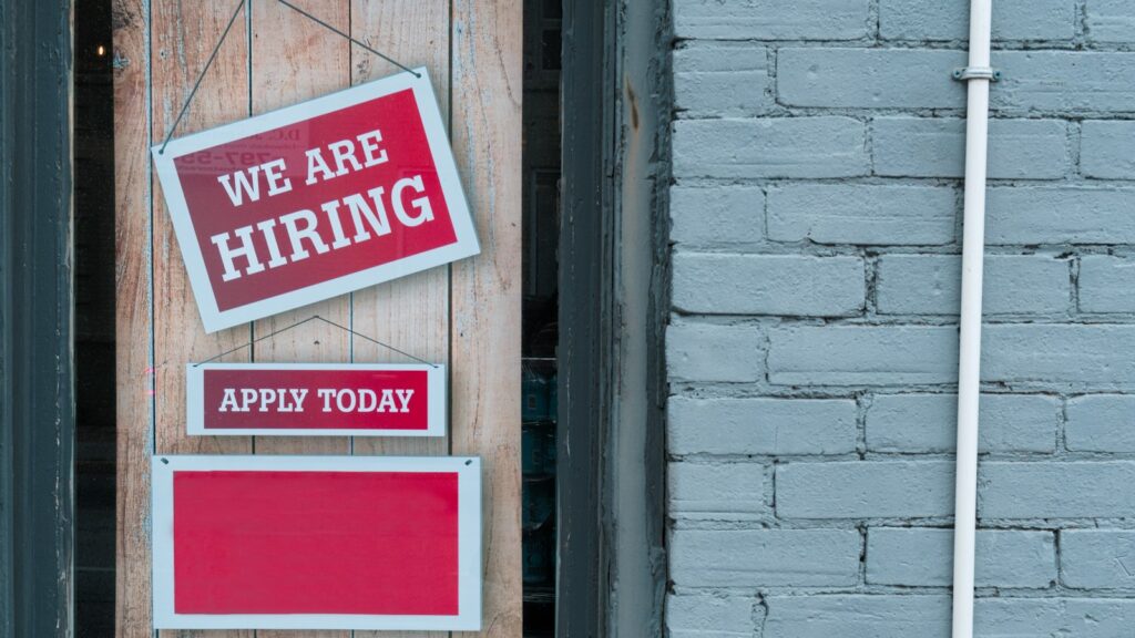 A sign that says we are hiring and apply today