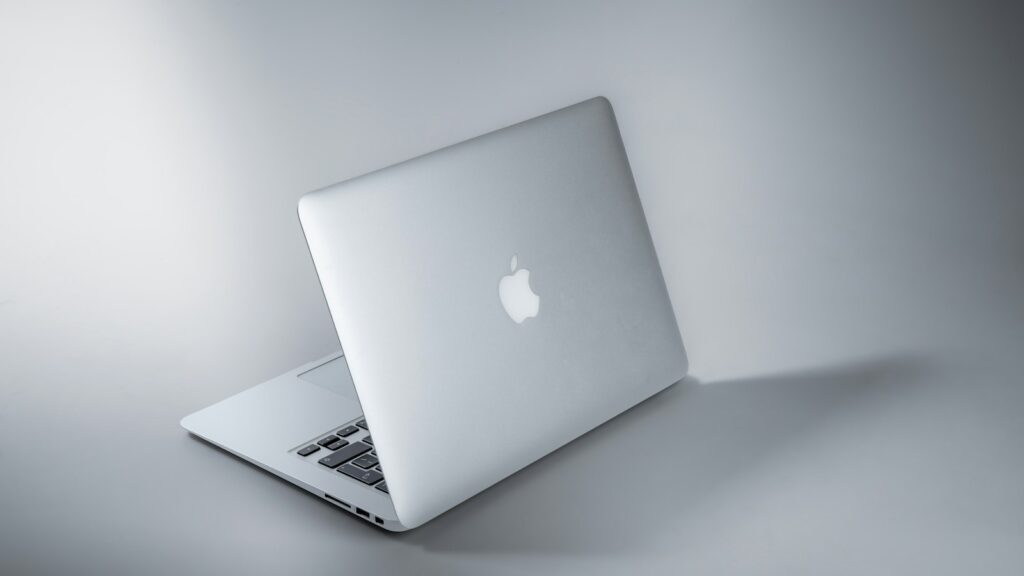 Silver macbook on white table