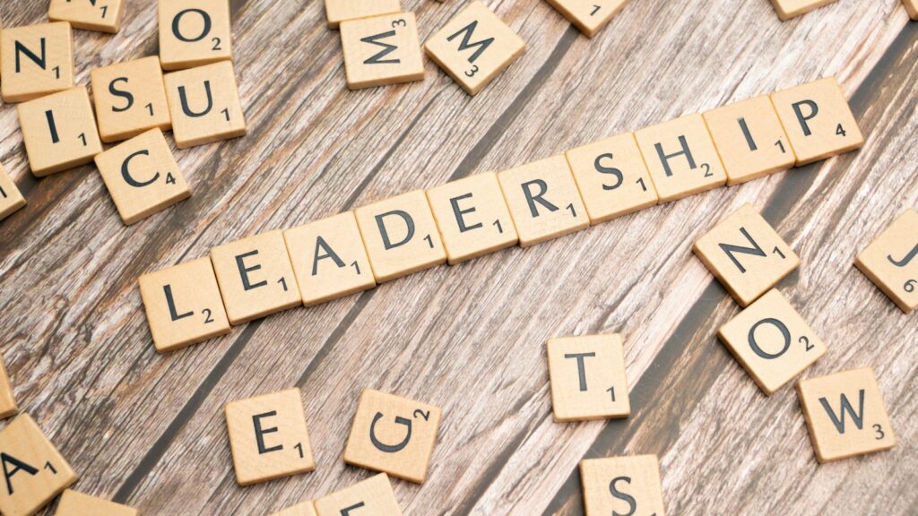 Scrabble tiles spelling out the word leadership on a wooden surface
