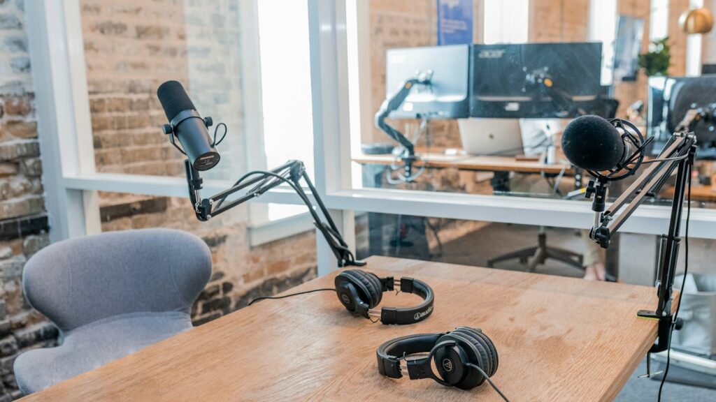Two black headphones on brown wooden table