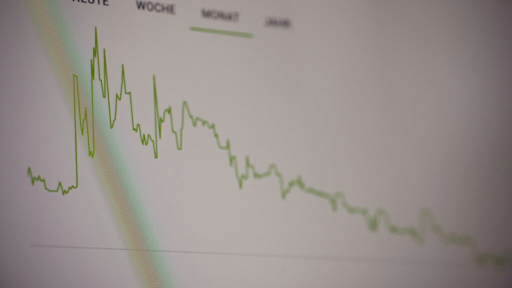 A green line graph showing stock market trends on a digital screen