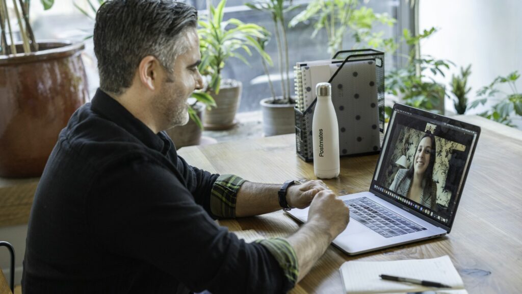 Man in black sweater using macbook pro