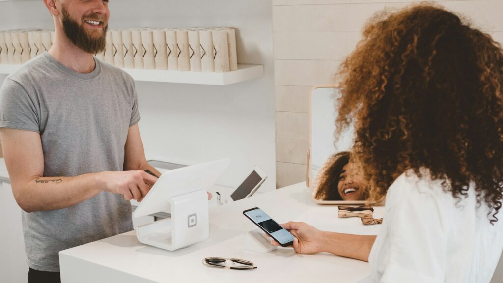 Man in grey crew-neck t-shirt smiling to woman on counter