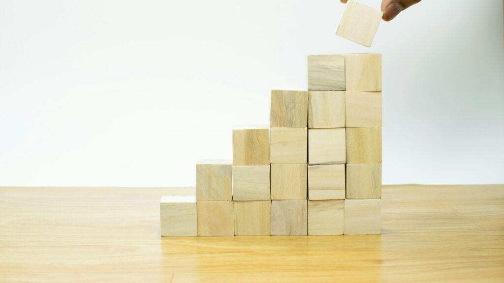 A person placing a piece of wood into a pyramid