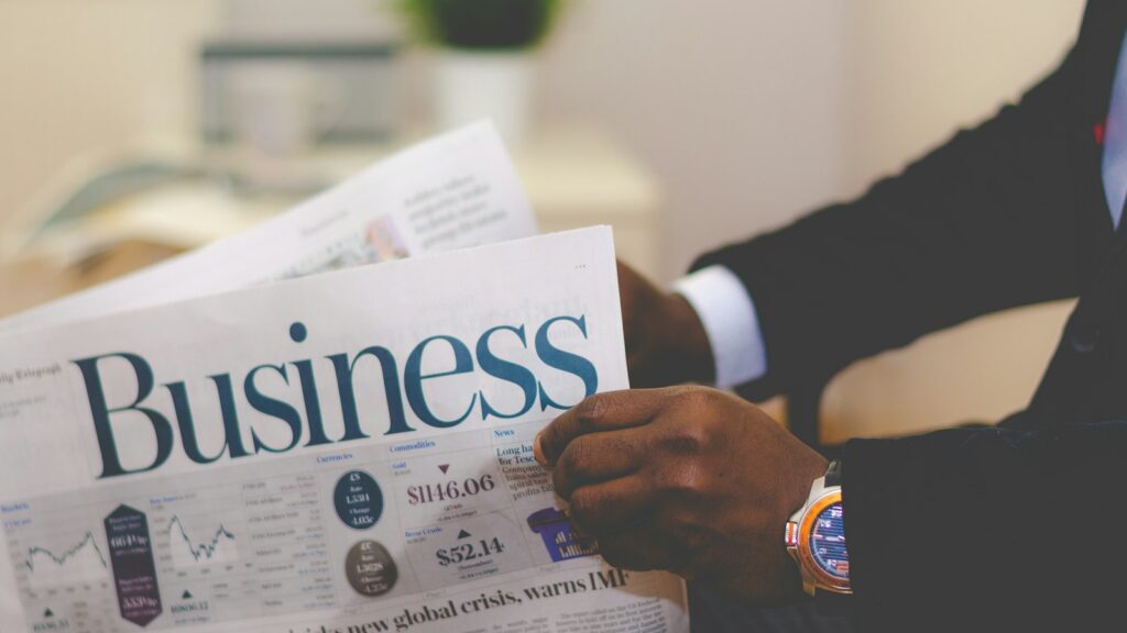Person wearing suit reading business newspaper