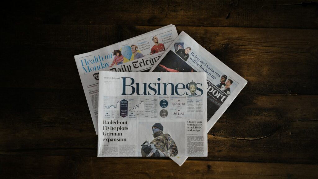 A stack of newspapers sitting on top of a wooden table