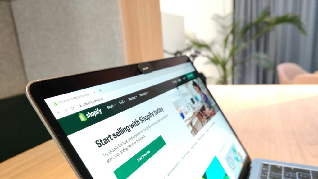 A laptop screen displaying a website on a wooden desk in an office