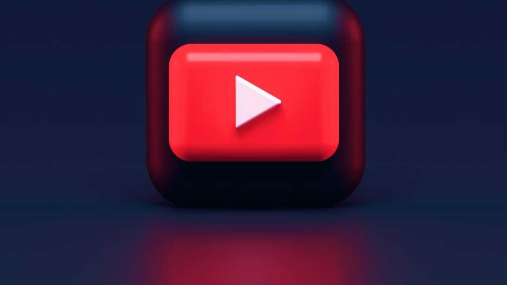A 3D red play button icon on a dark blue background