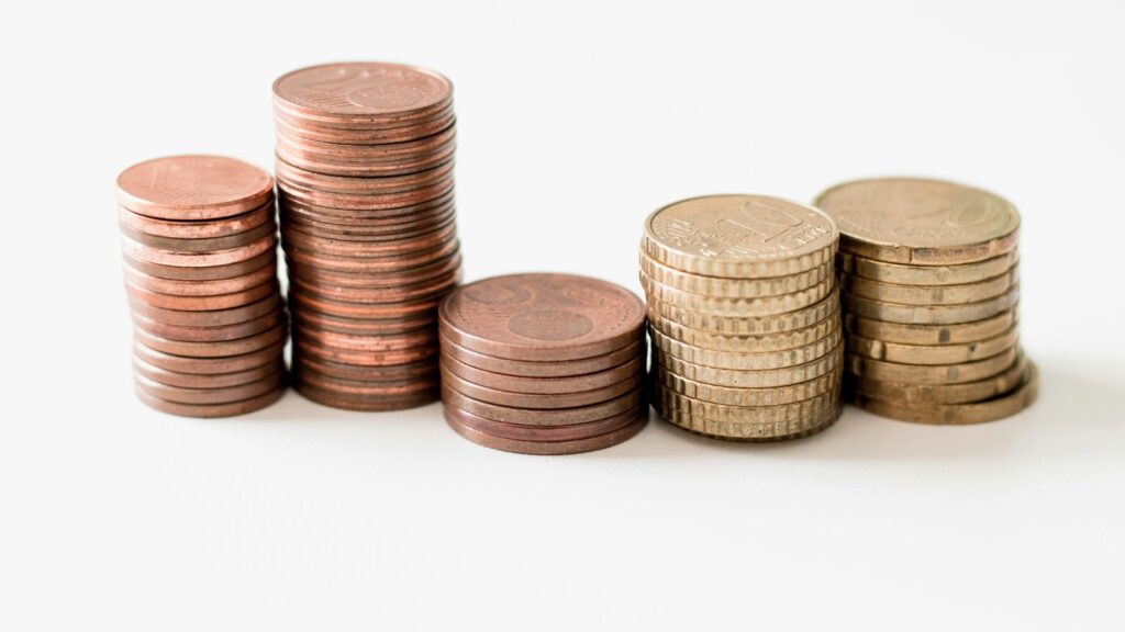 Stacked round gold-colored coins on white surface