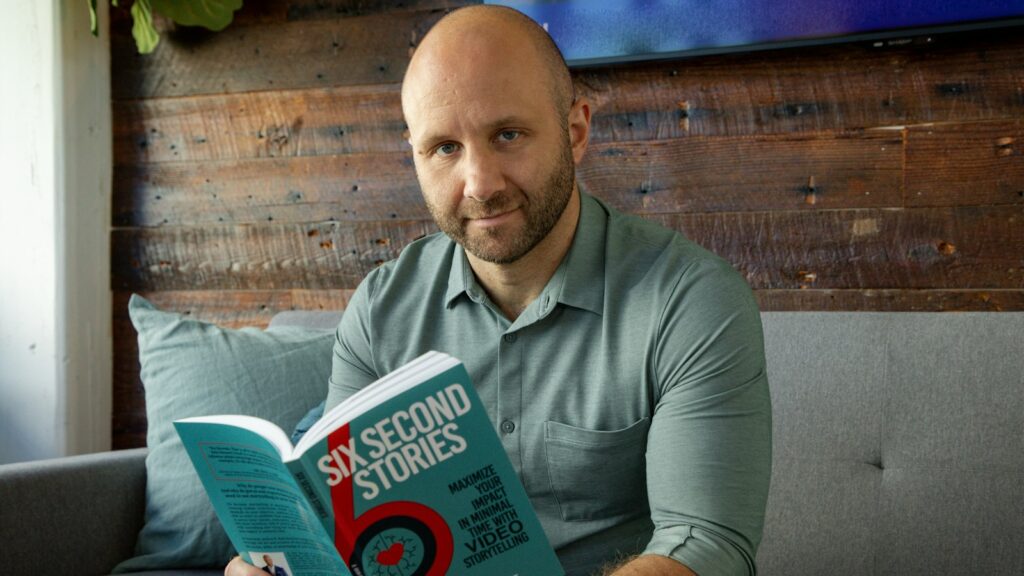 A man sitting on a couch holding a book